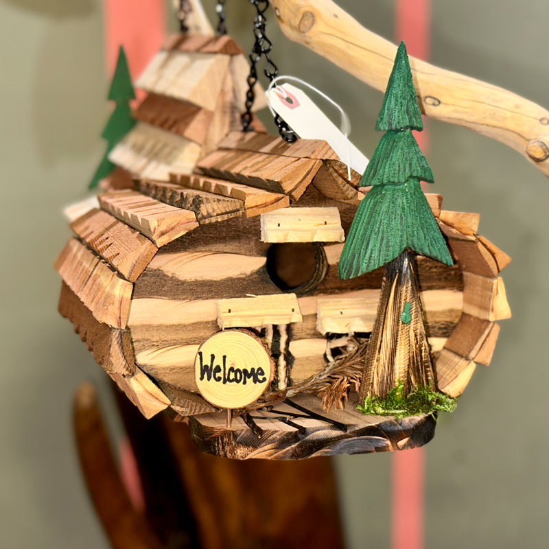 closeup of wooden bird house with a tree and welcome sign