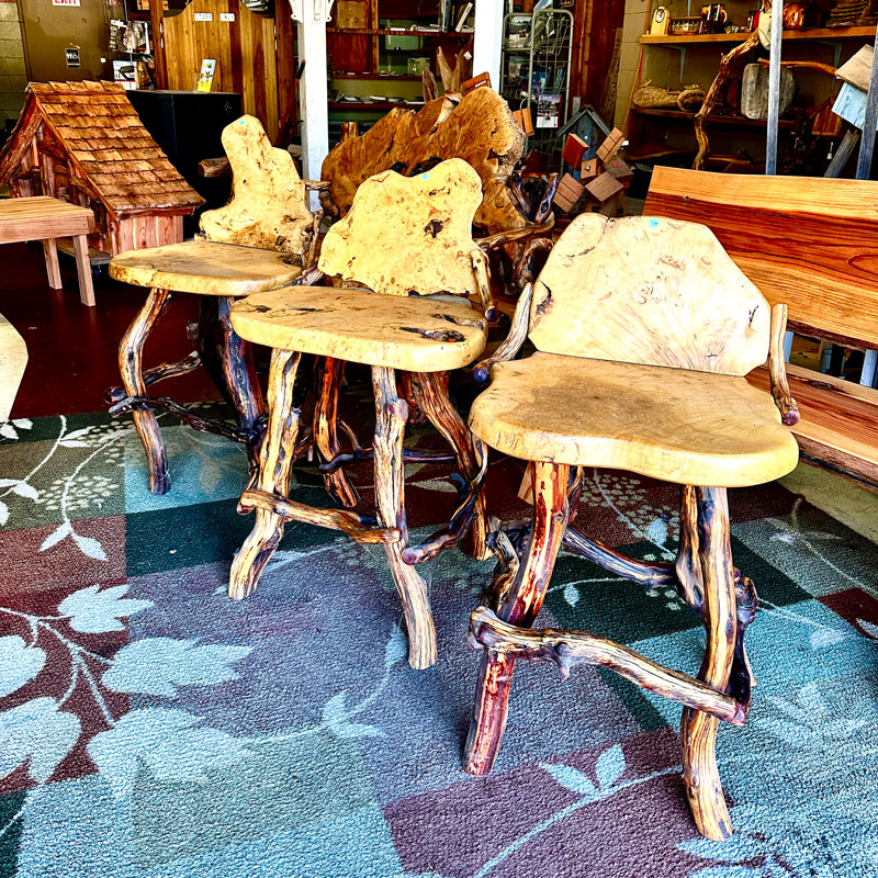 a trio of uniquely shaped wooden barstools